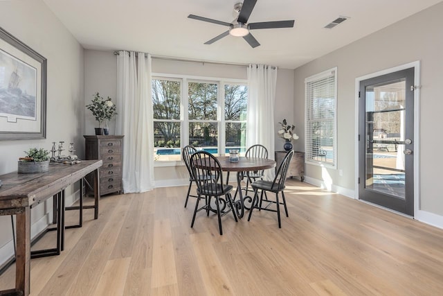 dining space featuring light wood-style flooring, baseboards, and visible vents