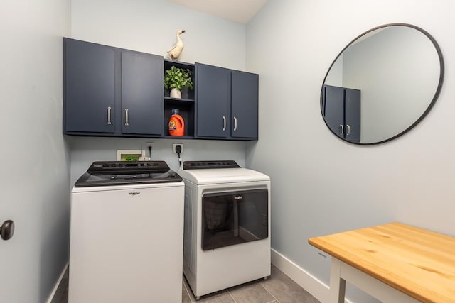 laundry area with light tile patterned floors, cabinet space, washer and dryer, and baseboards