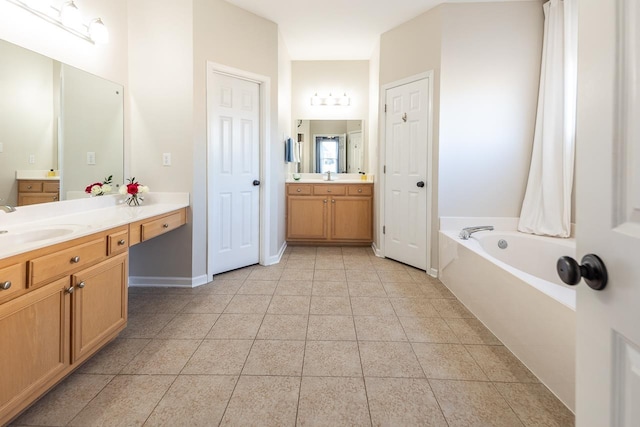 full bath featuring tile patterned flooring, two vanities, a garden tub, and a sink