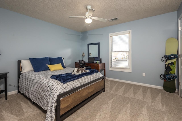 carpeted bedroom featuring visible vents, baseboards, a textured ceiling, and a ceiling fan