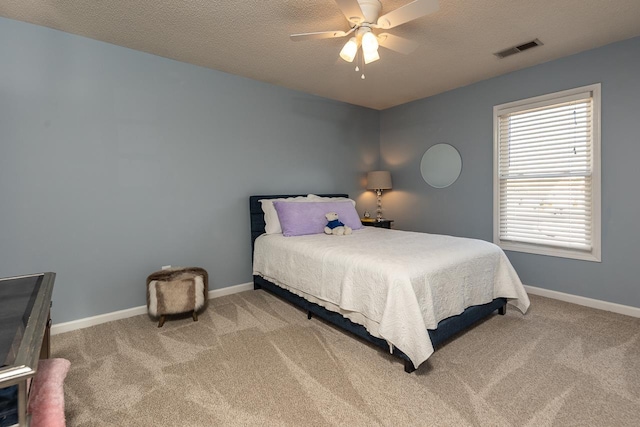 bedroom featuring visible vents, baseboards, carpet, and a textured ceiling