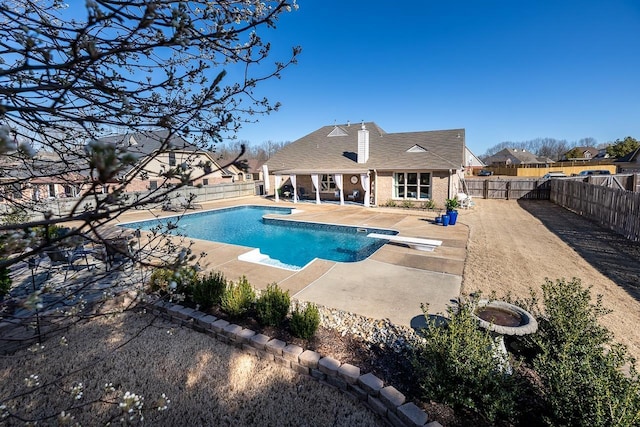 view of swimming pool with a fenced in pool, a patio area, a diving board, and a fenced backyard