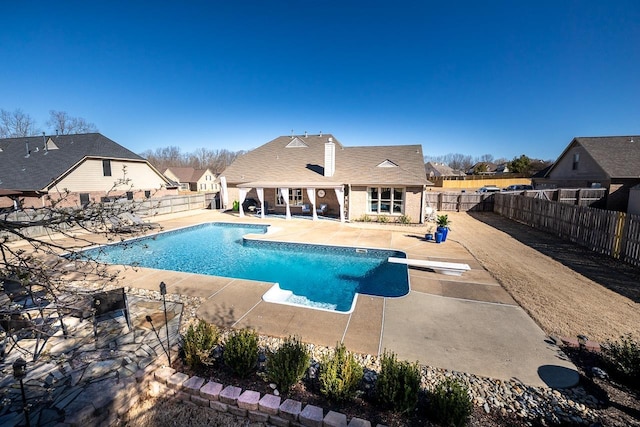 view of swimming pool with a patio area, a fenced in pool, a fenced backyard, and a diving board