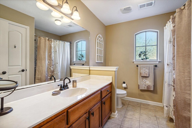 bathroom with vanity, toilet, baseboards, and visible vents