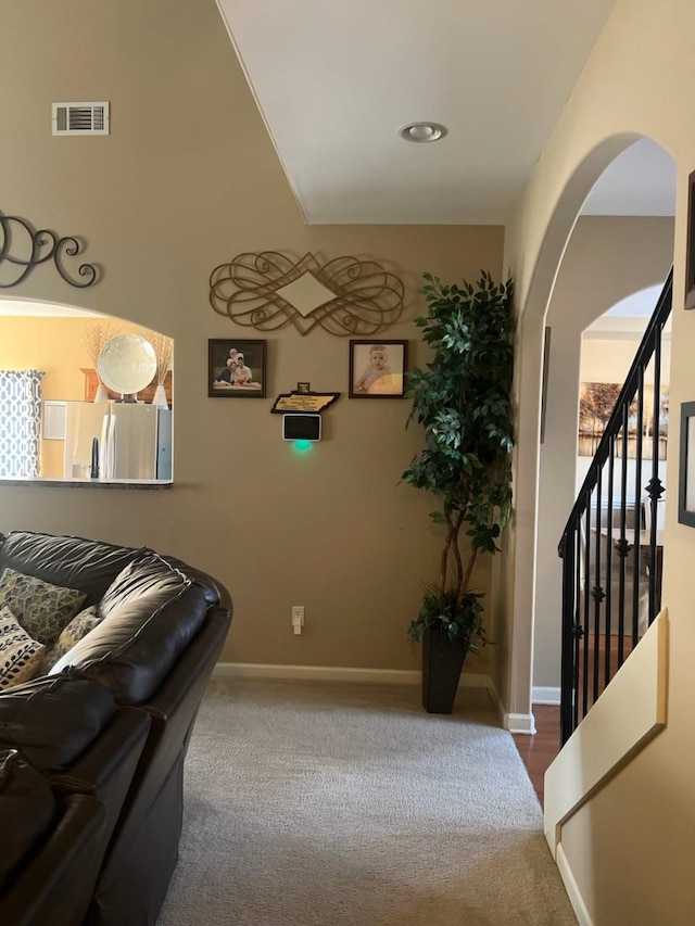 interior space featuring visible vents, baseboards, arched walkways, and stairs