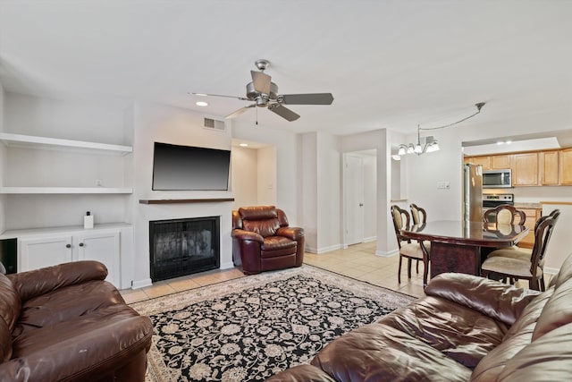 living room featuring visible vents, baseboards, a fireplace with flush hearth, light tile patterned flooring, and a ceiling fan