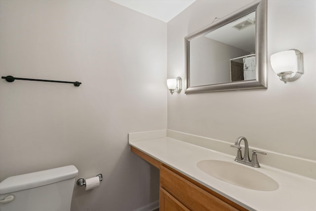 bathroom featuring visible vents, toilet, and vanity