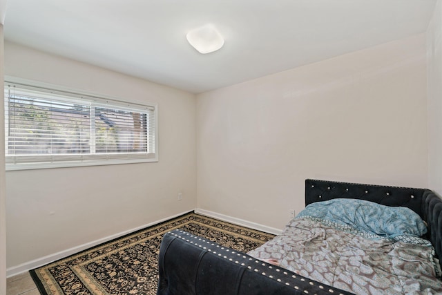 bedroom featuring tile patterned flooring and baseboards