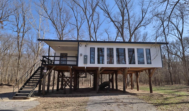 view of front of property with stairs, a carport, and metal roof