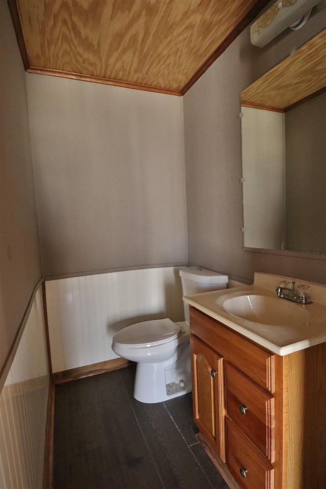 half bath with vanity, wood finished floors, toilet, and wood ceiling