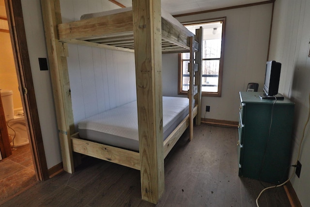 bedroom with wood-type flooring and wood walls