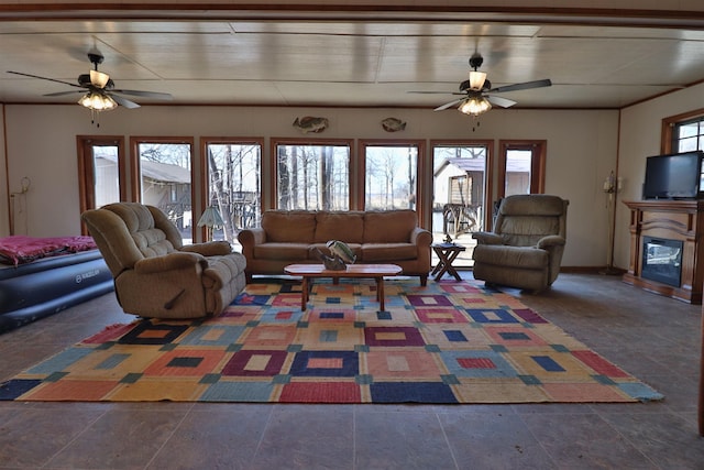 living room featuring a glass covered fireplace and a ceiling fan