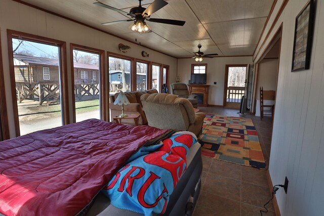 bedroom with wooden walls, dark tile patterned floors, and a fireplace