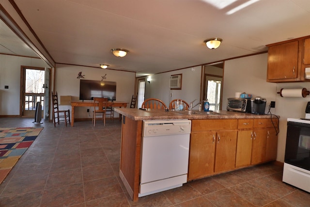 kitchen featuring brown cabinetry, a peninsula, white dishwasher, a sink, and range with electric stovetop