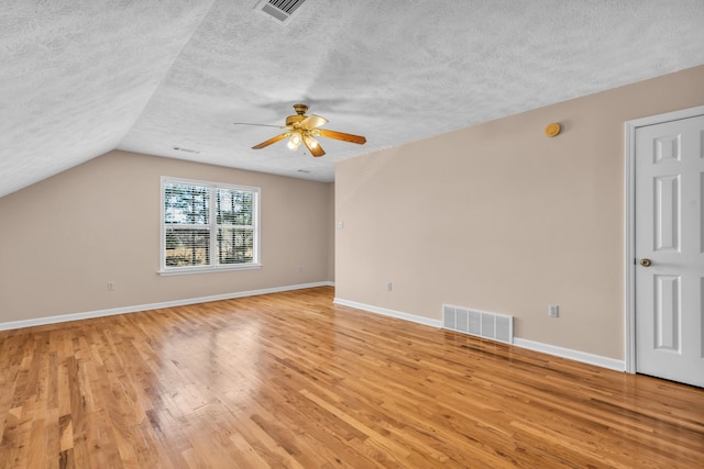 interior space with light wood finished floors, visible vents, a textured ceiling, and baseboards