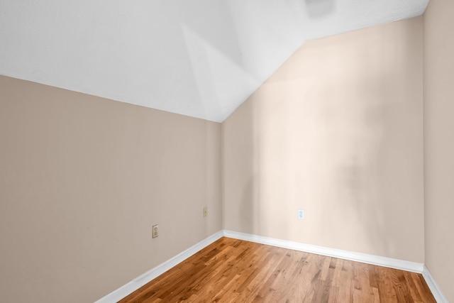 additional living space with lofted ceiling, wood finished floors, and baseboards