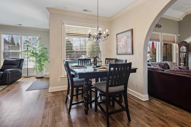 dining room featuring a wealth of natural light, visible vents, arched walkways, and crown molding