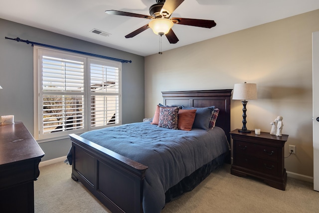 bedroom featuring visible vents, light colored carpet, baseboards, and ceiling fan