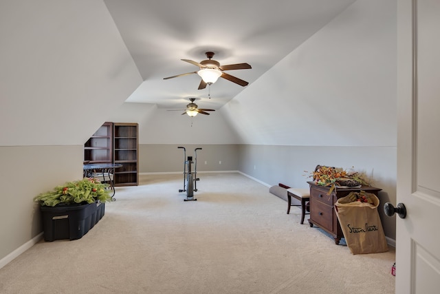 exercise area with vaulted ceiling, carpet flooring, baseboards, and ceiling fan