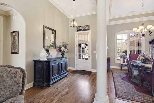 foyer with arched walkways, a notable chandelier, crown molding, and wood finished floors