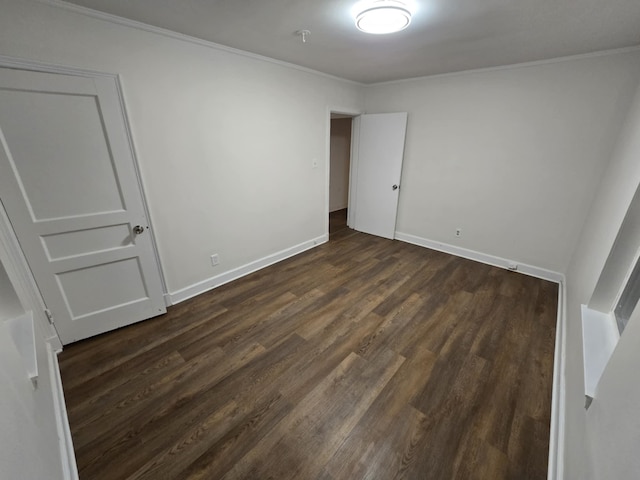 unfurnished bedroom with baseboards, dark wood-type flooring, and crown molding