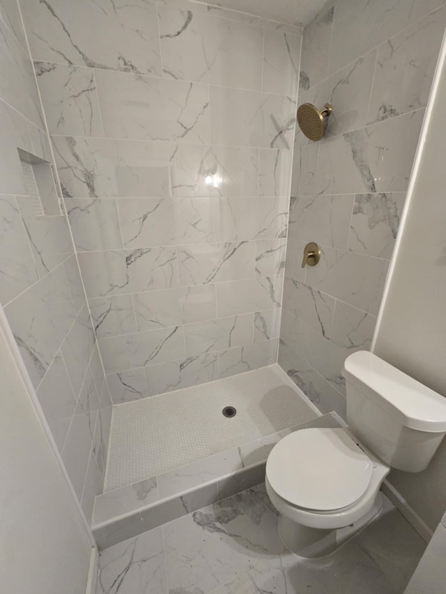 bathroom with a shower stall, toilet, and marble finish floor