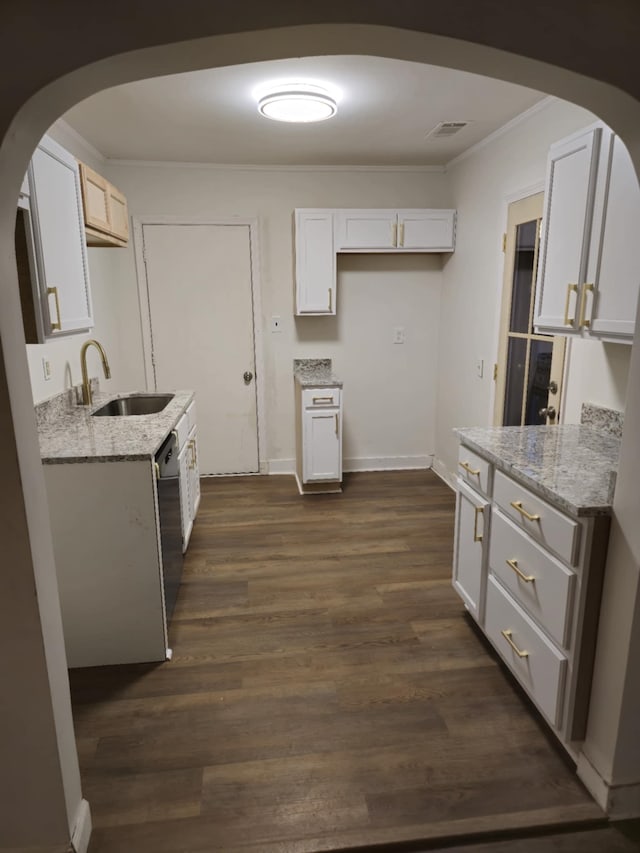 kitchen with light stone countertops, arched walkways, and a sink