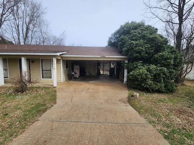 view of front facade featuring an attached carport, driveway, and a shingled roof