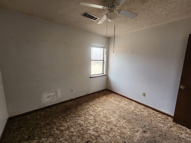 carpeted spare room featuring visible vents, baseboards, a textured ceiling, and ceiling fan