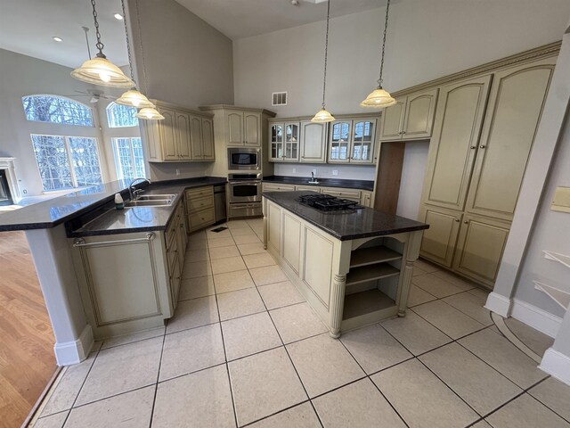 kitchen featuring visible vents, cream cabinetry, open shelves, dark countertops, and stainless steel appliances