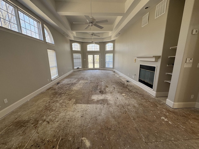 unfurnished living room with visible vents, baseboards, and a glass covered fireplace