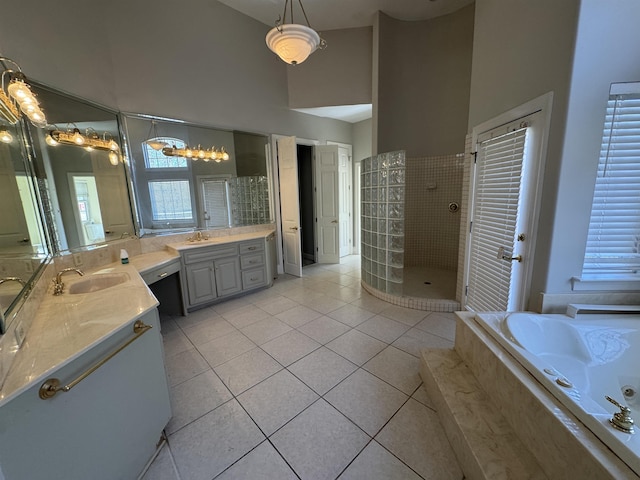 bathroom with tile patterned floors, high vaulted ceiling, a garden tub, a walk in shower, and a sink