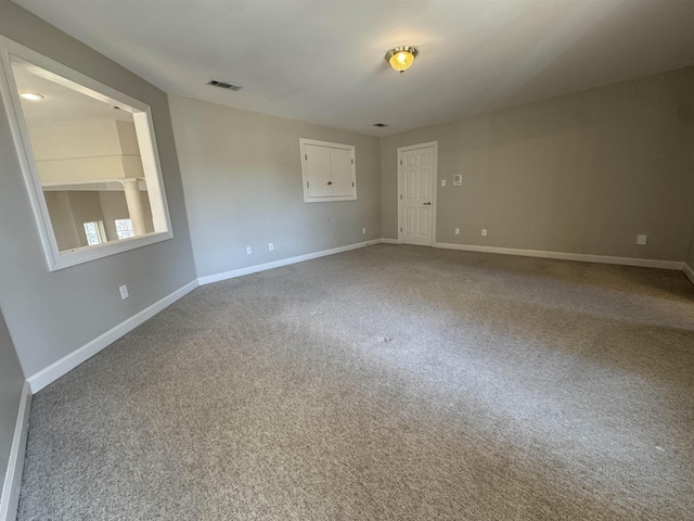 carpeted empty room with visible vents and baseboards