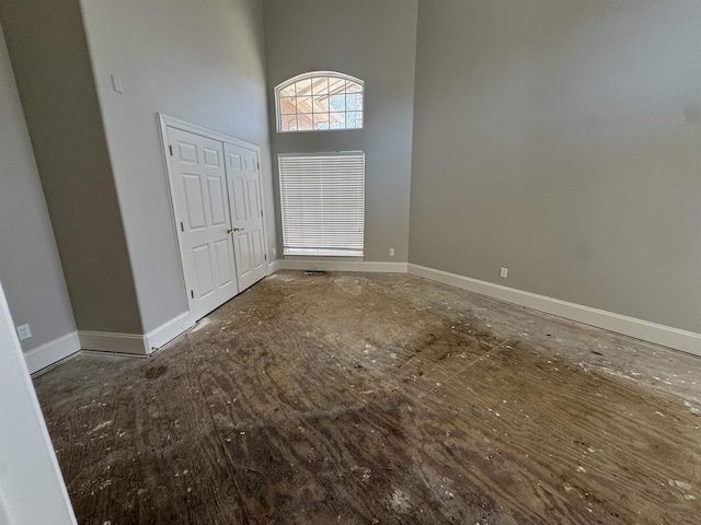 entryway featuring baseboards and a towering ceiling