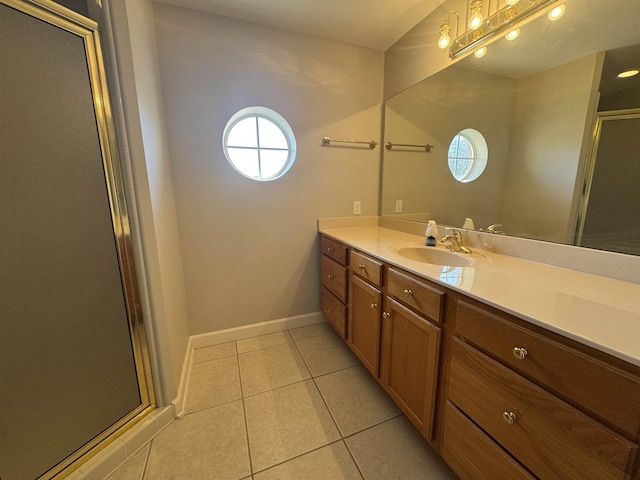 bathroom featuring baseboards, vanity, a shower stall, and tile patterned flooring