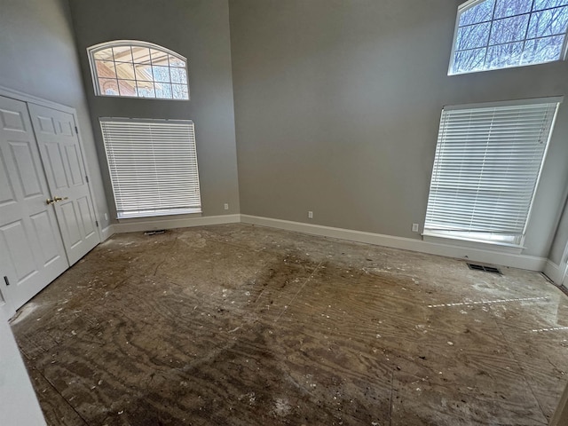 entrance foyer with visible vents, baseboards, and a high ceiling