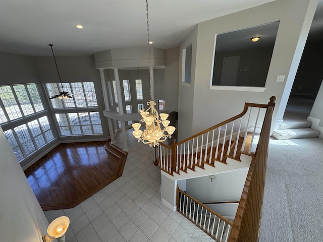 stairway with an inviting chandelier, tile patterned floors, and baseboards