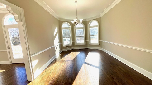 unfurnished dining area with baseboards, an inviting chandelier, ornamental molding, and dark wood-style flooring