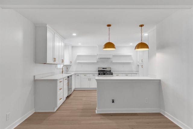 kitchen featuring a sink, open shelves, light wood finished floors, and stainless steel appliances