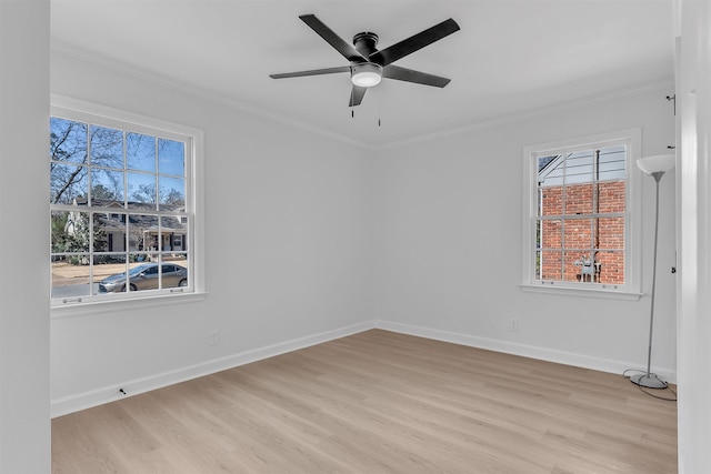 spare room with light wood-type flooring, baseboards, and ornamental molding