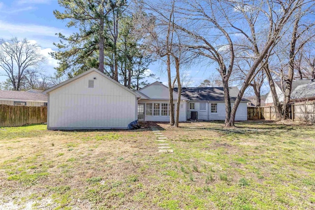 back of house featuring central air condition unit, a yard, and a fenced backyard