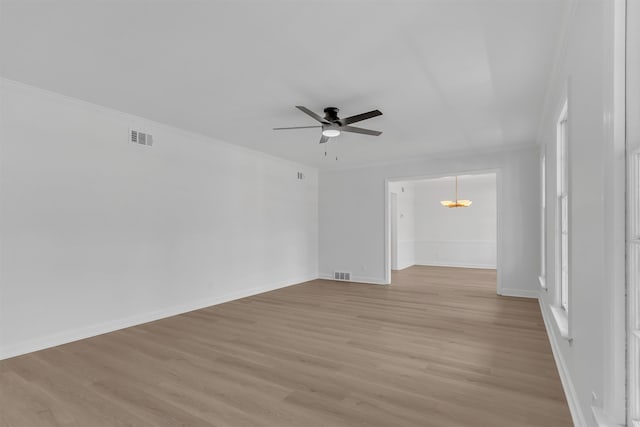 unfurnished room featuring light wood finished floors, visible vents, and crown molding