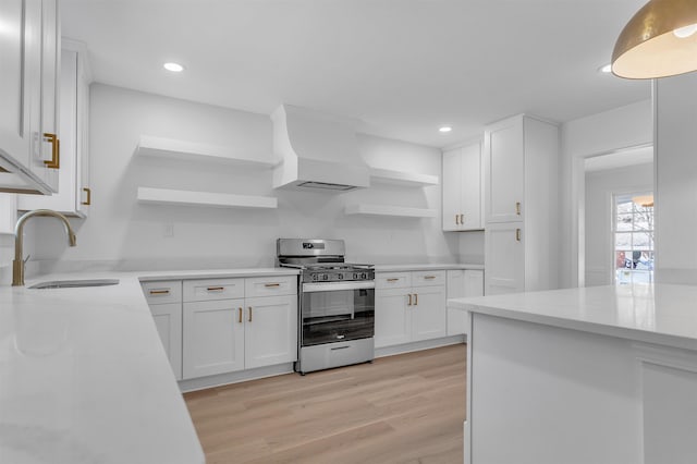 kitchen with premium range hood, open shelves, a sink, white cabinetry, and stainless steel gas range