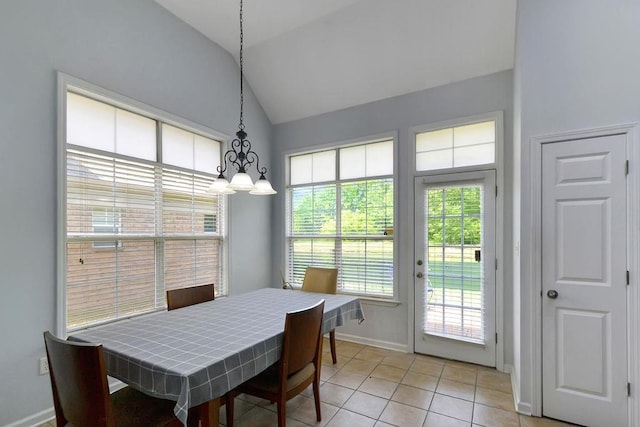 dining space with light tile patterned floors, baseboards, lofted ceiling, and a notable chandelier