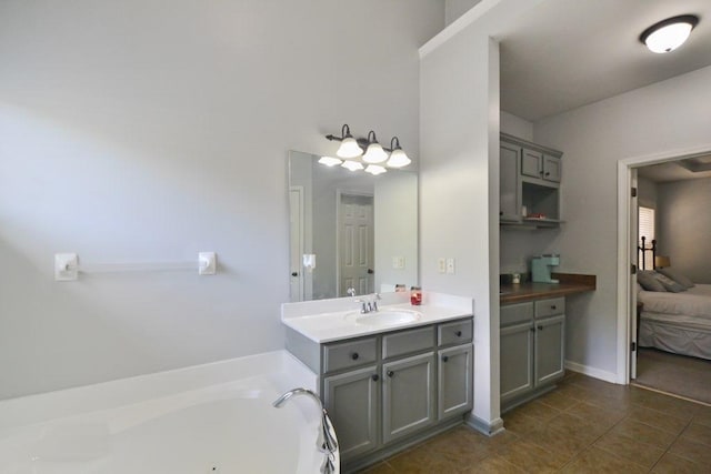 ensuite bathroom featuring vanity, a bath, tile patterned flooring, and connected bathroom