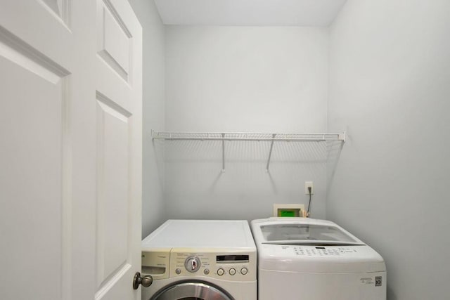 clothes washing area featuring laundry area and washer and clothes dryer