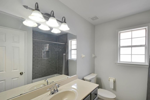 bathroom with vanity, toilet, visible vents, and a wealth of natural light