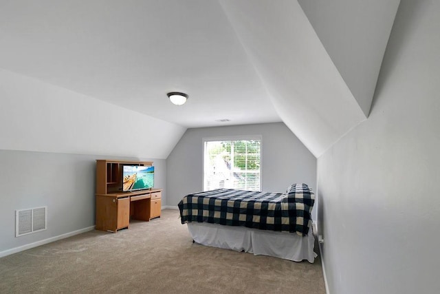 bedroom with light colored carpet, lofted ceiling, baseboards, and visible vents