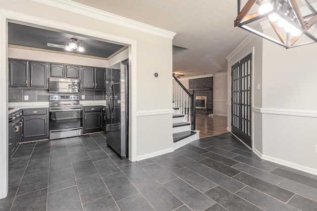 kitchen featuring dark tile patterned flooring, ornamental molding, backsplash, stainless steel appliances, and light countertops