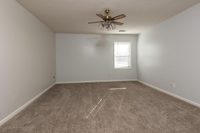 carpeted empty room with visible vents, ceiling fan, a textured ceiling, and baseboards